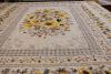 A colorful quilt with a yellow sunflowers and creams.