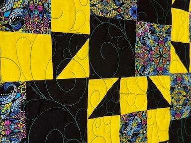 Yellow & Black Quilt yellow and black half squares triangles with dark paisley squares for contrast.